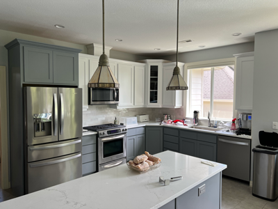 Modern kitchen with white and grey cabinets, chrome appliances