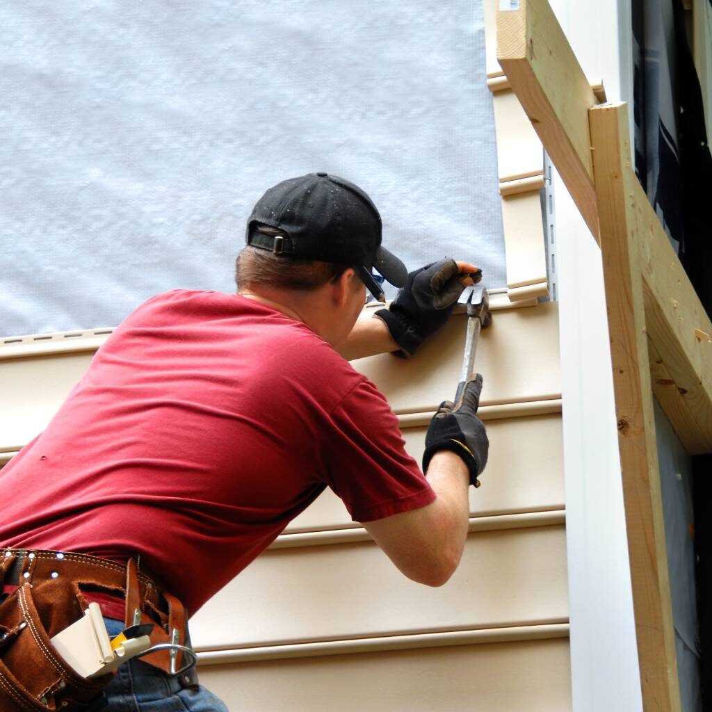 Person hammering new siding