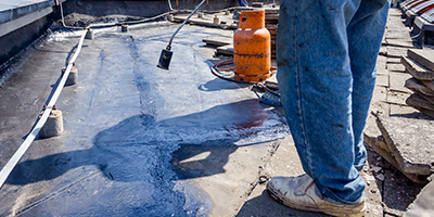 Man on roof installing torch down roofing in cape coral