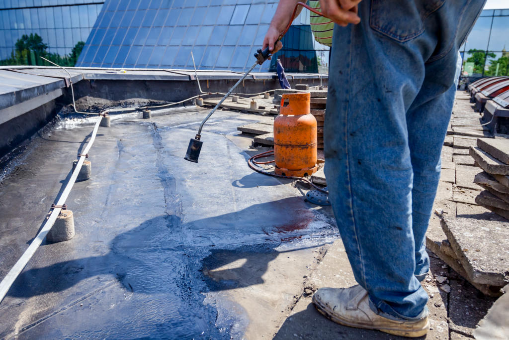 Man on roof installing torch down roofing in Portland OR, Bend OR, and Vancouver WA areas